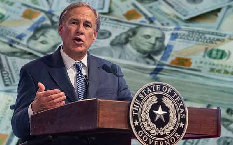 Texas Gov. Greg Abbott speaks in front of a large stack of cash